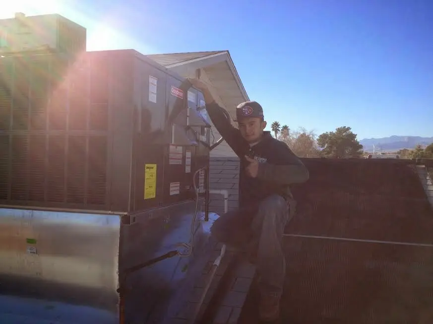 HVAC technician performing AC Tune-Up on a rooftop unit in Sierra Vista